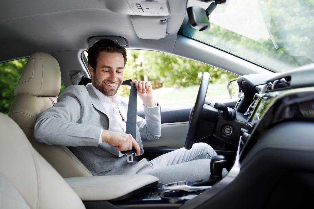 safe driving image of man putting on seat belt